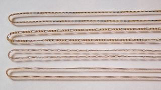 Four thin 18k gold chains laid straight: venetian box, figaro and two curb chains