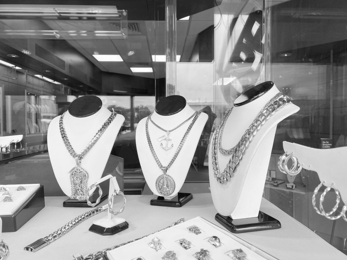 Jewelry store window in Miami with heavy Cuban link chains on display busts
