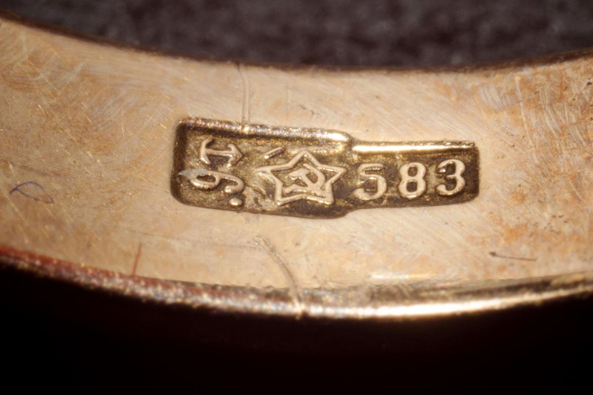 Macro of a gold ring band stamped 583 next to a Soviet star assay mark